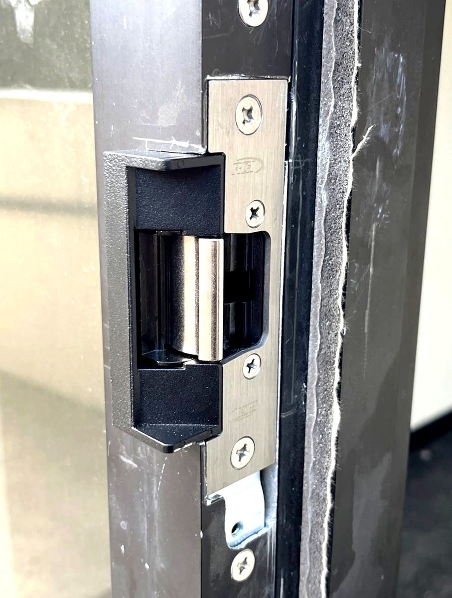 An electric strike fitted into a commercial door frame