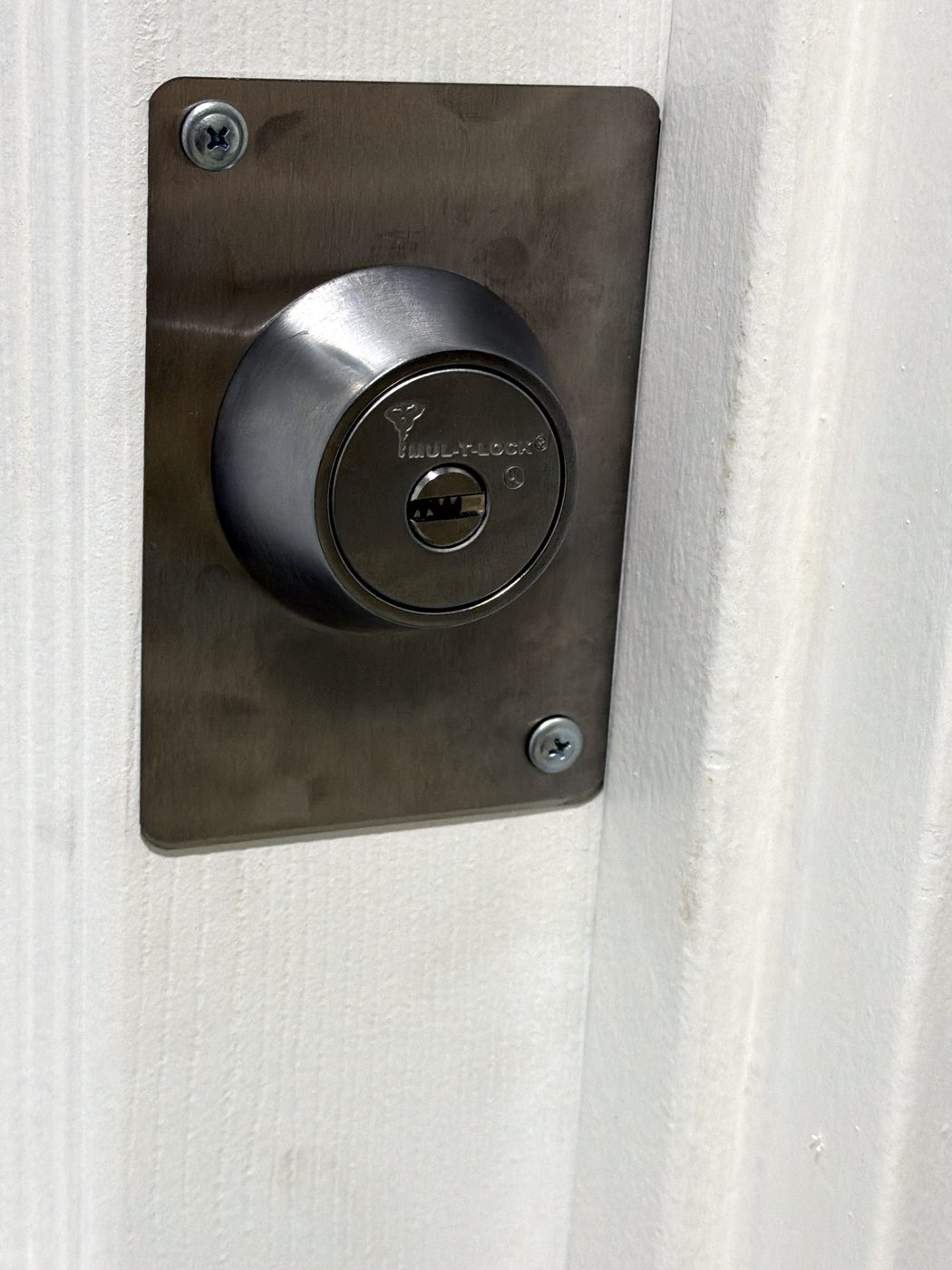 A Mul-T-Lock cylinder fitted in a stainless escutcheon on a customer’s door