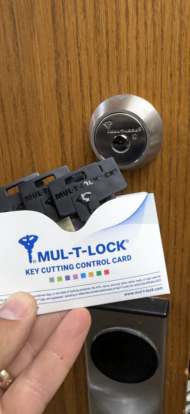 A Mul-T-Lock deadbolt on a customer’s door, with the keys and the Key Cutting Control Card that comes with it