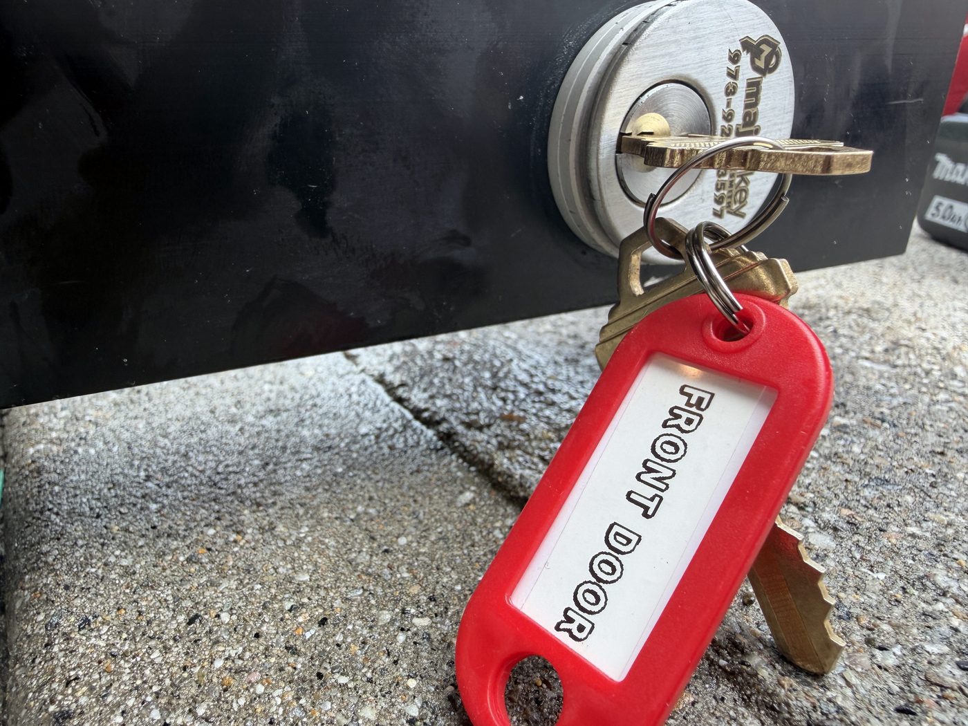 A cut key tagged FRONT DOOR before it goes in the box — every key labelled so nobody has to guess later