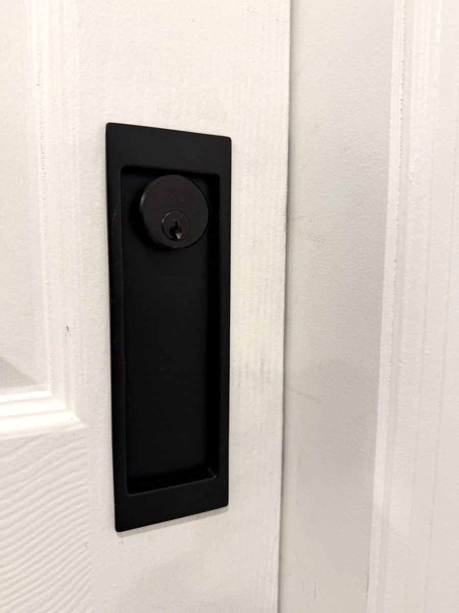 The finished recessed lock, flush with the face of the pocket door